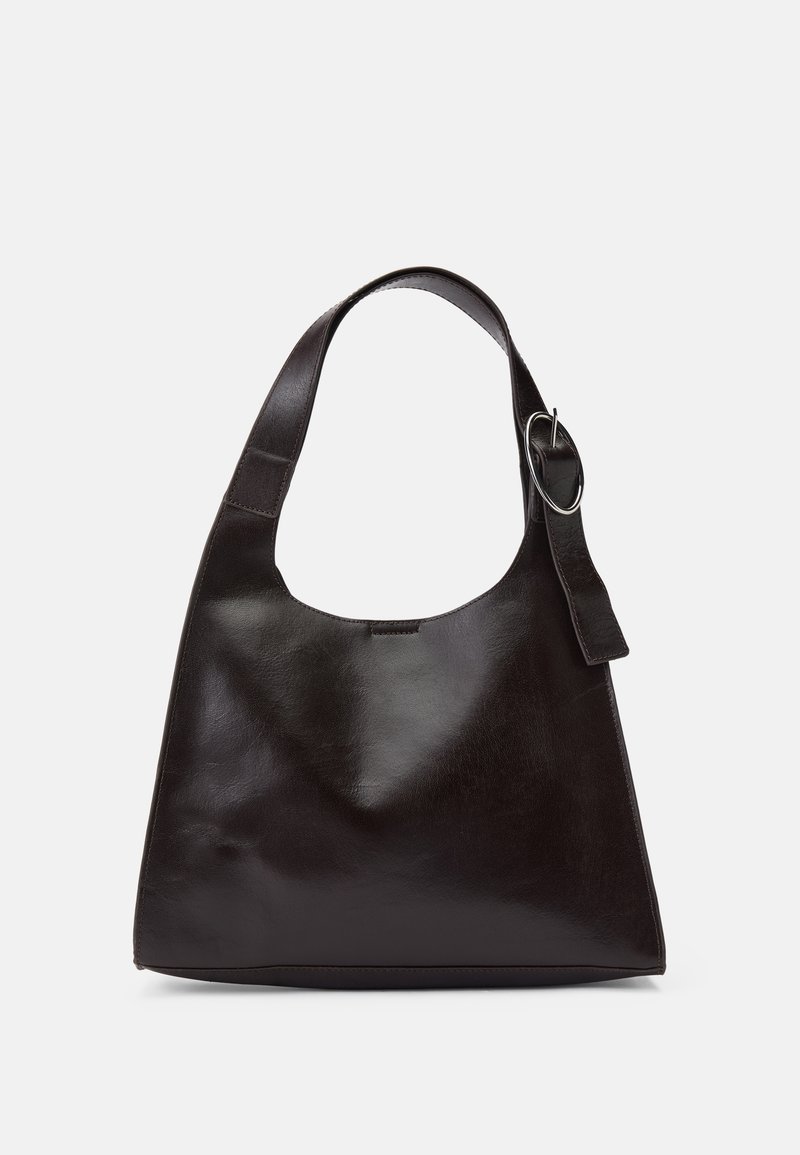 Brown leather shoulder bag with a smooth texture, rounded shape, wide strap, and circular metallic accent on the handle.