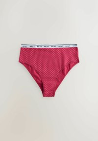Red polka dot high-waisted panties with a white band featuring the "NEXT" logo. Smooth fabric with a fitted design and subtle sheen.