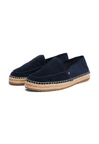Zapatos slip-on de ante azul marino con suela de yute. Presenta detalles cosidos a lo largo de la parte superior y un pequeño acento de la marca en el lateral.