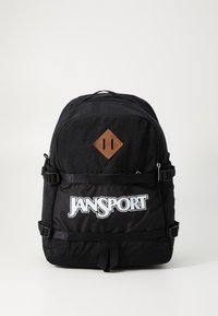 Sac à dos noir en tissu durable, doté d'un patch en cuir texturé en forme de diamant et d'un logo blanc bien visible sur la poche avant.