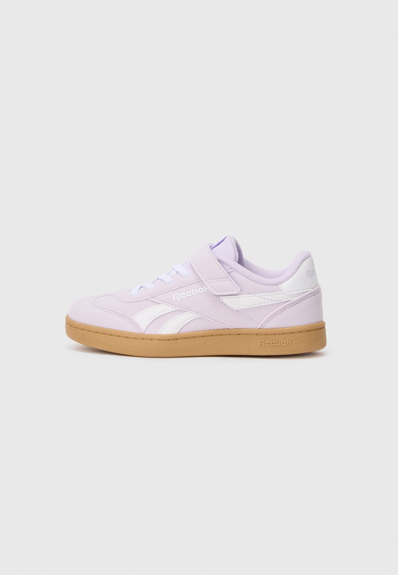 Baskets de sport lilas avec une bande latérale blanche, une sangle velcro et une semelle en caoutchouc. Tige en textile lisse avec des détails cousus.