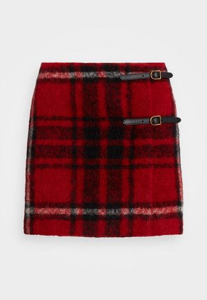Red wool plaid skirt with black and white check pattern, featuring two black leather buckle straps on the right side.