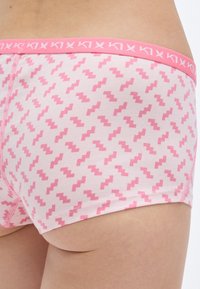 Ροζ μποξέρ σορτς με ζιγκ-ζαγκ μοτίβο, κατασκευασμένα από μαλακό βαμβάκι, με ροζ ζώνη μέσης που έχει λογότυπο και ραμμένα άκρα.