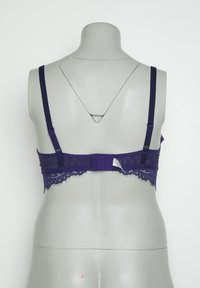 Lila Spitzen-BH mit verstellbaren Trägern, einem gewellten Spitzenrand und einem Haken- und Ösenverschluss auf der Rückseite. Flache Stoffoberfläche.