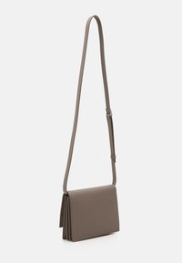 Bruine synthetische crossbodytas met een lange verstelbare riem, met een rechthoekige vorm en een gladde textuur, en een subtiele gestikte detail aan de voorkant.