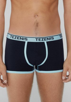 Boxers en coton noir avec des accents et une ceinture bleu clair portant le logo "TEZENIS". Coupe ajustée avec un design de poche contournée.