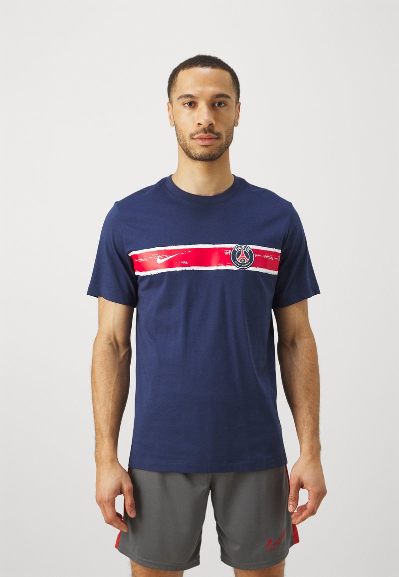 Tumesinine puuvillane T-särk, millel on horisontaalne punane ja valge triip ning "Paris" logo koos Nike'i swooshiga. Lühikesed varrukad, ümmargune kaelus.