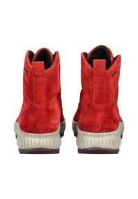 Stivaletti alla caviglia in suede rosso con finitura testurizzata e suola in gomma grigia. Presenta un pratico passante sul retro e un branding minimo sul lato.