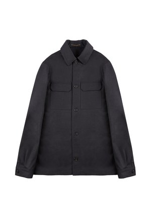 Veste boutonnée bleu marine foncé en tissu épais, avec un col, deux poches poitrine et des poignets boutonnés. Design minimaliste.