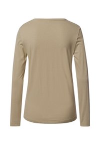 Top beige de manga larga con cuello redondo. Hecho de un tejido suave, tiene una textura lisa y un ajuste entallado sin adornos.