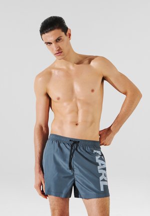 Shorts da bagno da uomo in grigio scuro, realizzati in materiale leggero, con vita elastica e cordoncino e stampa del logo in grassetto sul lato.