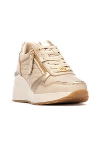 Zapatilla beige chunky con textura acolchada, acentos en dorado y una suela blanca elevada. Presenta un cierre lateral con cremallera y un diseño de cordones.