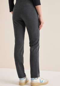 Grijze op maat gemaakte broek met een geweven structuur, voorzien van een tailleband en achterzakken, gecombineerd met witte sneakers met blauwe accenten.