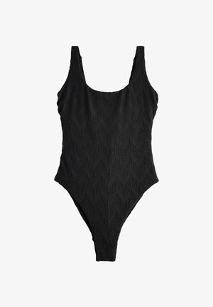 Costume intero nero con spalline larghe e motivo a zigzag strutturato, mostrato steso su sfondo bianco.