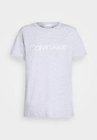 Šedé tričko s krátkým rukávem vyrobené z měkkého materiálu, které na přední straně obsahuje bílé logo "Calvin Klein" a má kulatý výstřih.