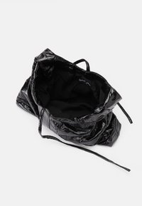 Μαύρη, δερμάτινη τσάντα με κορδόνι, με λείο και γυαλιστερό εξωτερικό. Μαλακό μαύρο εσωτερικό, ευρύχωρος σχεδιασμός και λεπτές δερμάτινες ιμάντες.