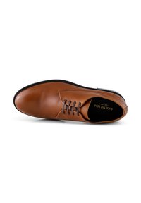 Chaussure en cuir marron avec une texture lisse, dotée d'un bout rond, d'un laçage et d'une semelle noire mince. Intérieur doublé d'un matériau contrastant.