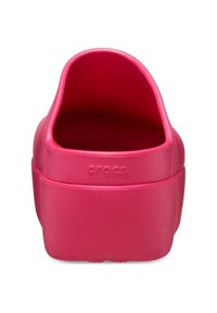 Zuecos Crocs rosas con un acabado suave y mate. El diseño sin parte trasera presenta una suela gruesa y un logotipo en relieve en el talón. Forma simple y plana.