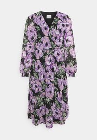 Květinové zavinovací šaty z lehké tkaniny. Mají fialové a bílé květiny na černém pozadí, dlouhé rukávy a výstřih do V.