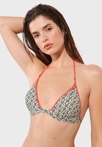 Bikini top s čierno-bielym vzorom, hlbokým V-výstrihom, oranžovým lemovaním a nastaviteľnými ramienkami, s hladkou TEXTÚROU a ľahkým materiálom.