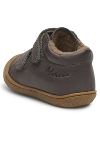 Stivale alla caviglia in pelle marrone con una morbida fodera interna, striscia in velcro e suola in gomma testurizzata, con un logo sul lato.