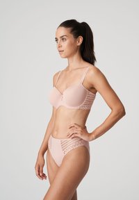 Light pink lingerie set featuring a smooth bra with lace accents and matching high-waisted briefs, showcasing a seamless design and delicate texture.