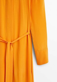 Orangenes Kleid mit langen Ärmeln, tailliertem Bund, glatter Textur und geradem Schnitt. Verfügt über eine verdeckte Knopfleiste und umgekrempelte Ärmel.