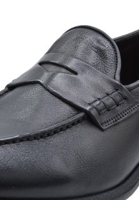 Czarne skórzane mokasyny o teksturowanym wykończeniu, z przednim paskiem i przeszyciami wzdłuż krawędzi.