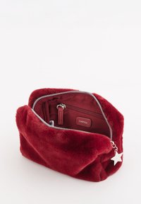 Rød pels kosmetiktaske med lynlåslukning. Indvendigt har den en lynlåslomme og et mærkelabel. Pyntet med en lille sølvstjernedekoration.