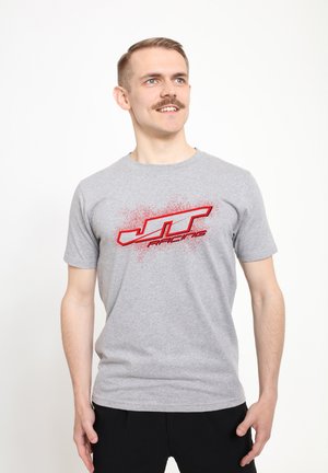 Grå bomulds t-shirt med rund hals, prydet med et rødt sprøjtet "JT Racing" logo på forsiden. Enkel design, korte ærmer.