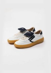Hvide lædersneakers med en marineblå Accent, der har en tekstureret gummisål og en stor velcrorem på tungespidsen.