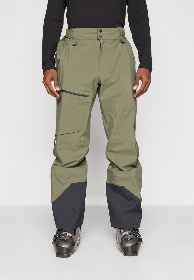 Pantaloni de zăpadă impermeabili, verzi, cu un panou inferior negru, buzunar lateral cu fermoar, talie ajustabilă și mansete întărite pentru durabilitate.