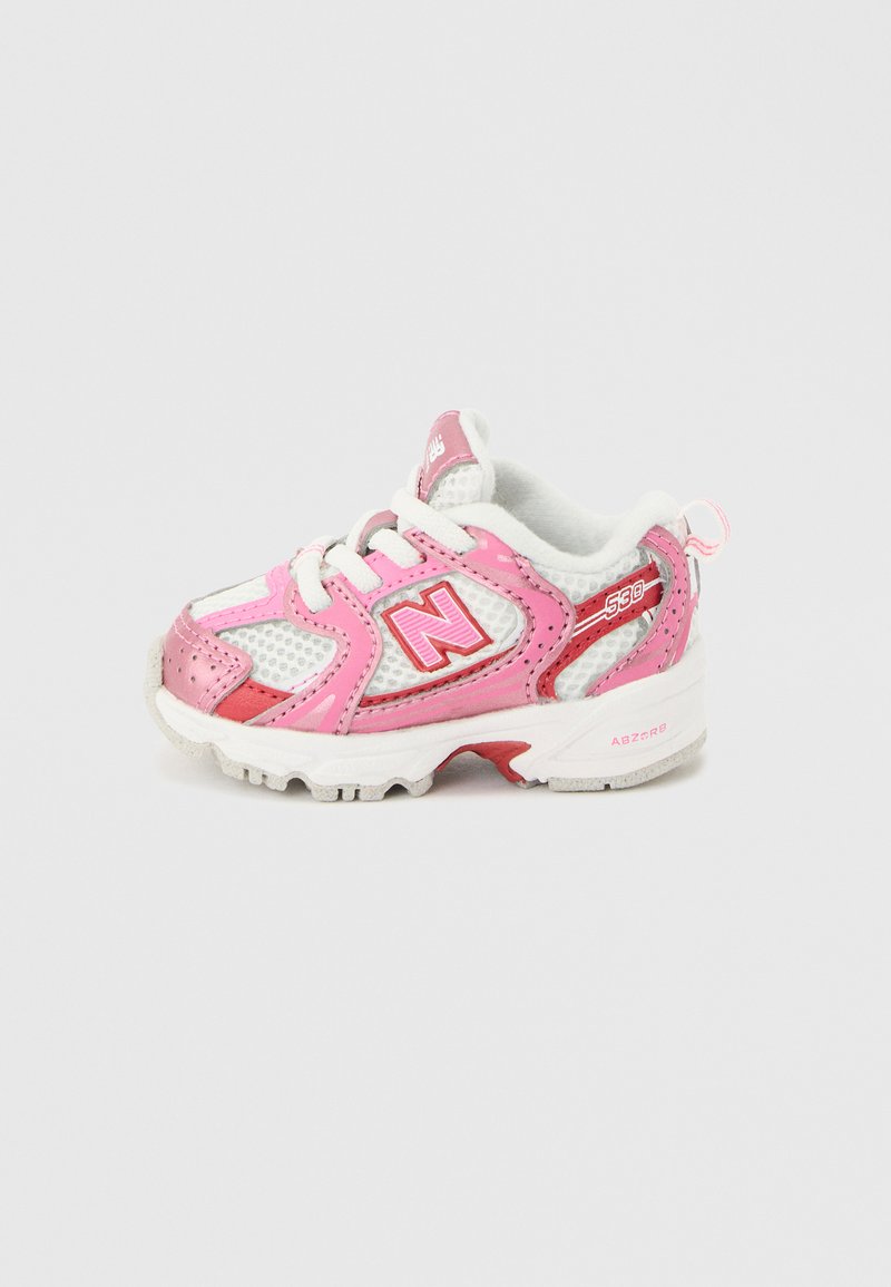 Λευκό και ροζ παπούτσι για νήπια με το λογότυπο "N" της New Balance, με δίχτυ ύφασμα και μαλακή σόλα, που φαίνεται από την εξωτερική πλευρά σε φωτεινό φόντο.