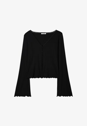 Melnas ribota garām piedurknēm blūze ar V veida kakla izgriezumu, viļņotu malām, mežģīņu apdari ap kaklu un priekšējo pogu aizdari. Īsāka dizaina.
