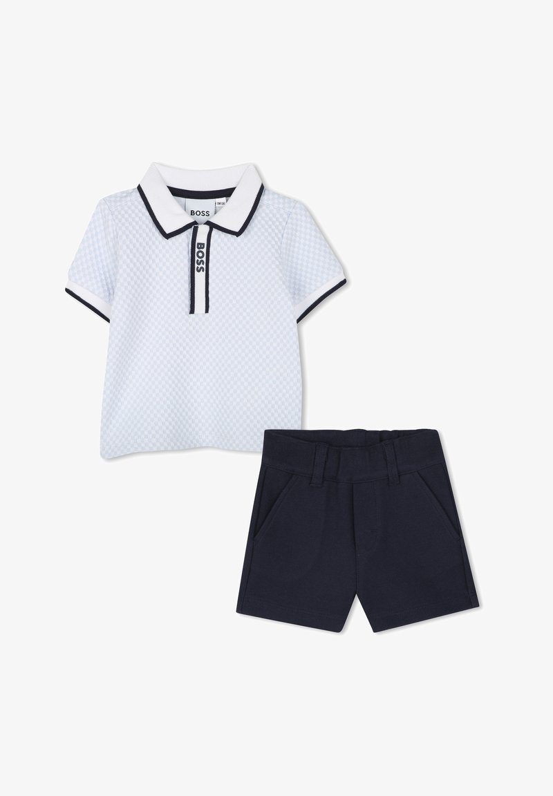 Polo azzurro chiaro a maniche corte con motivo a quadri e dettagli blu navy, abbinato a pantaloni in blu navy con tasche frontali e passanti per cintura.