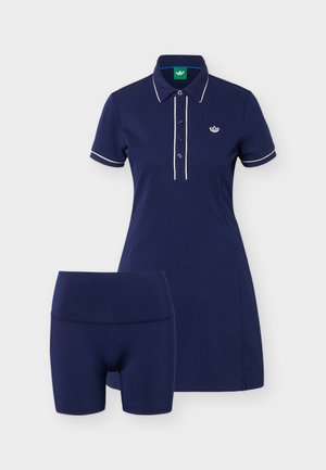 Μπλε ναυτικό πόλο φόρεμα με λευκή περίγραμμα και αντίστοιχα μπλε ναυτικά σορτς για ποδηλασία, με μικρό λευκό λογότυπο στο στήθος του φορέματος.