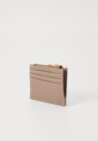 Tarjetero en material sintético beige claro con cuatro ranuras para tarjetas y un compartimento con cremallera, con costuras blancas y herrajes dorados.