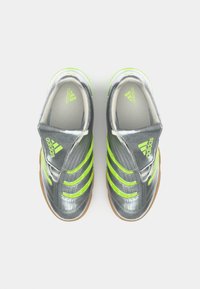 Sivi atletski tenisice s tri svijetlosmeđe pruge, teksturiranom gornjom jastučićem, gumeni potplat i Adidas logo na jeziku i strani. Glatka završna obrada.