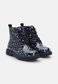 Botines de charol negro con estampados de corazones coloridos, puntera redonda, cordones en la parte delantera y suelas de goma para mayor tracción.