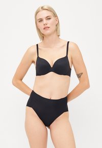 Svarte undertøy sett bestående av en glatt, formet bh med justerbare stropper og høyt liv truser. Stoffet er elastisk og sømløst.