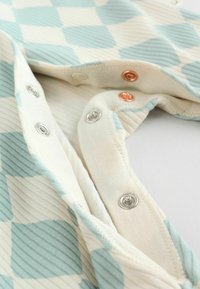 Pamut szövet, világos krém alapszínnel, kék kockás és csíkos mintázattal. Ezüst és réz tónusú fémsnap gombokkal.