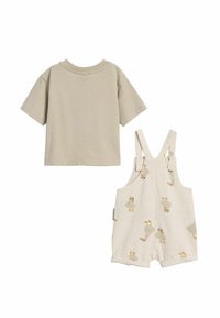 Beige T-shirt met korte mouwen in combinatie met witte tuinbroeken met een eendenpatroon. Zachte katoenen stof; de tuinbroeken hebben verstelbare banden en opgerolde zomen.