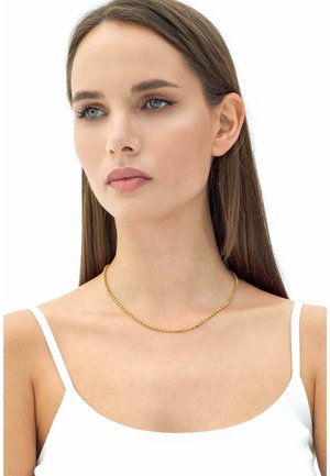 Collana in oro con un design elegante, caratterizzata da piccoli anelli interconnessi. Indossata sulla pelle nuda, con una semplice maglietta bianca come sfondo.