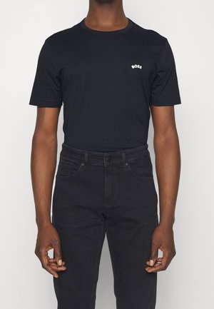 Sort bomulds T-shirt med rund hals og korte ærmer. Har et lille hvidt "BOSS" logo på brystet. Parret med mørke jeans.