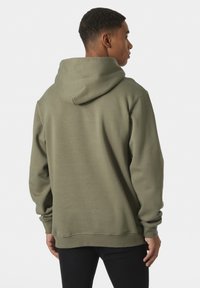 Sudadera verde oliva hecha de tela suave. Presenta una gran capucha, puños acanalados y un corte relajado, mostrando una textura suave y un diseño sencillo.