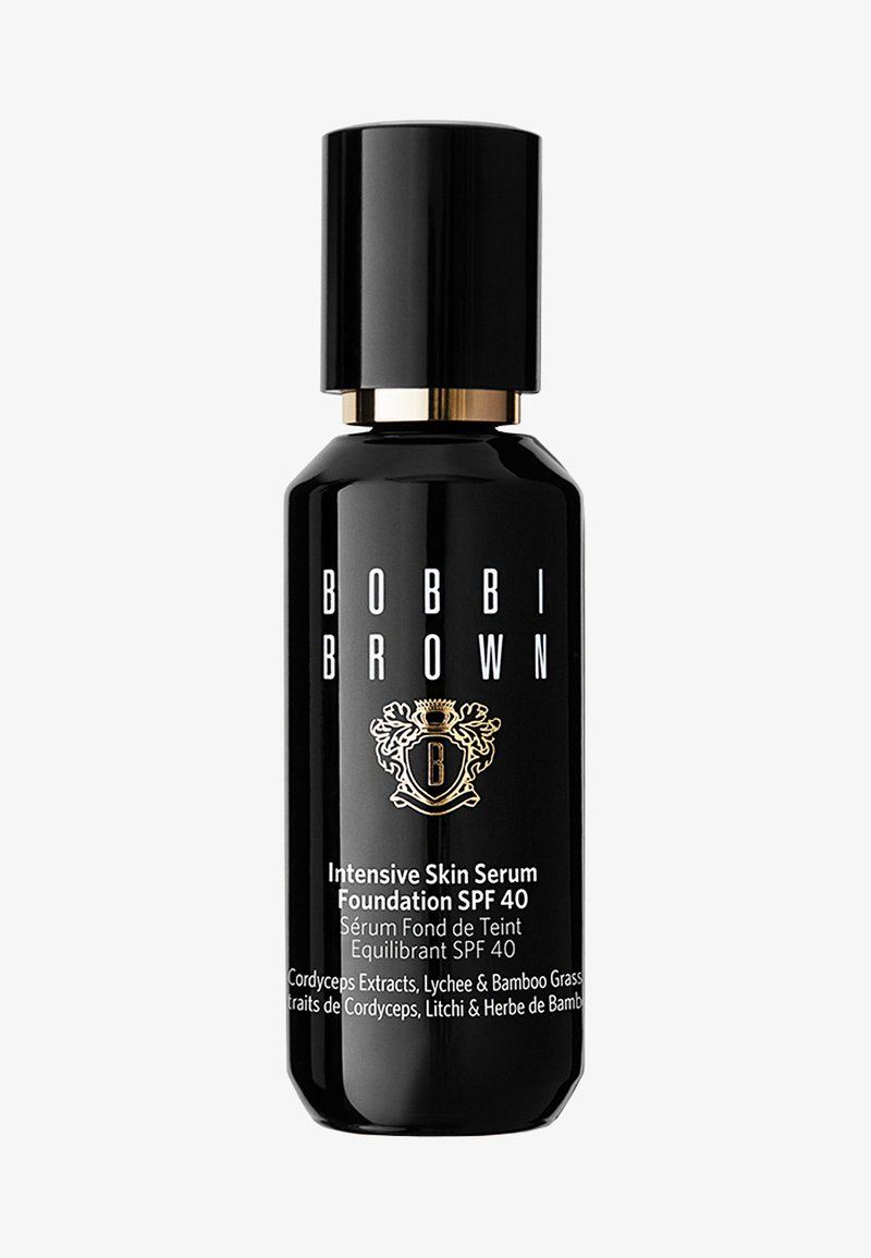 Bouteille cylindrique noire avec un bouchon à accent doré, étiquetée "Bobbi Brown Intensive Skin Serum Foundation SPF 40" avec un logo décoratif et du texte.