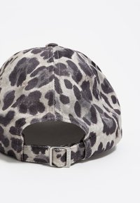 Gorra de felpa con estampado de leopardo, hecha de pana, con un ala curvada y una correa metálica ajustable en la parte posterior para un ajuste seguro.