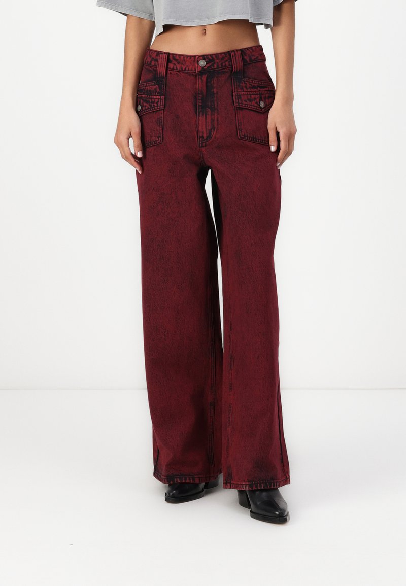 Pantaloni in denim bordeaux a gamba larga con una texture sbiadita, dotati di due tasche frontali e chiusura con bottone in vita.