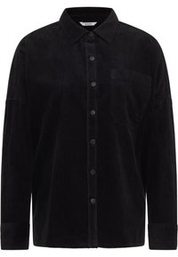 Camisa de pana negra con cierre de botones en el frente, cuello puntiagudo, bolsillo en el pecho y mangas con puños. La textura de costillas verticales añade profundidad.