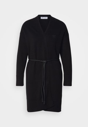 Mustast kootud kardigan, millel on mähise disain, pikas varrukas, sidumisrihm, soonikud ja tekstuuriline muster. Koonitud logo detail.